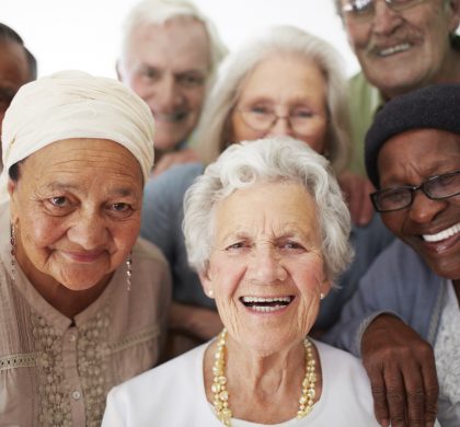 A group of seniors smiling together while in a retirement home